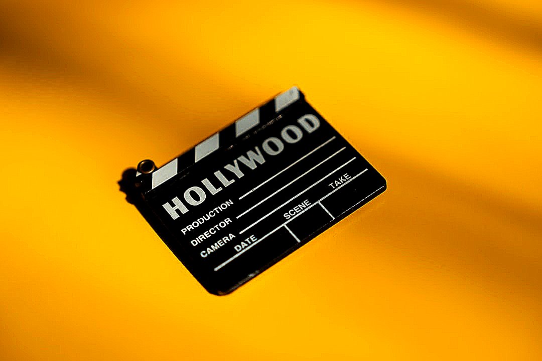 A hollywood movie clapperboard on a yellow background.