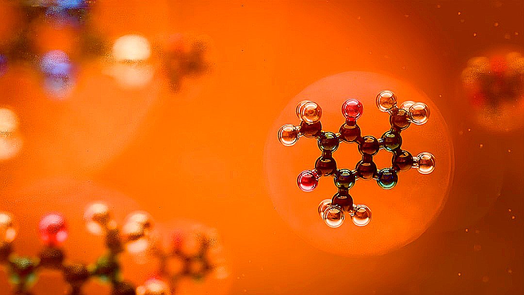 Molecular structures are seen against an orange backdrop.