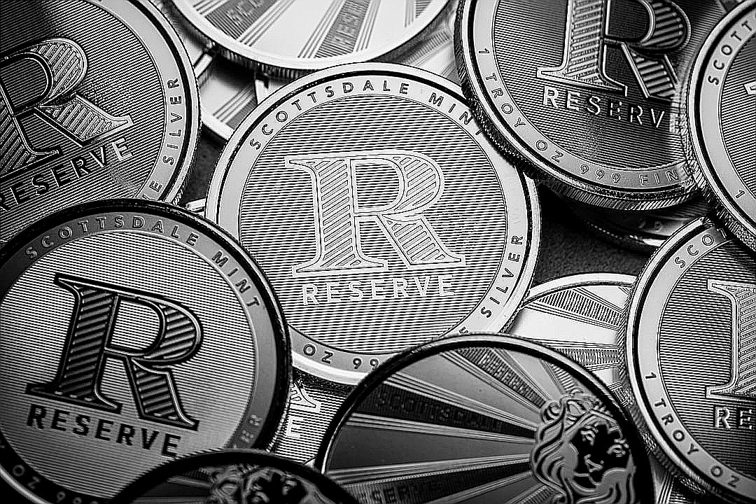 a pile of silver and black coins