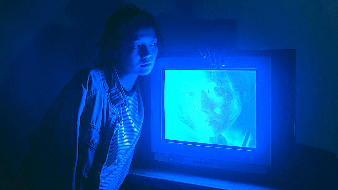 a person standing in front of a television in a dark room