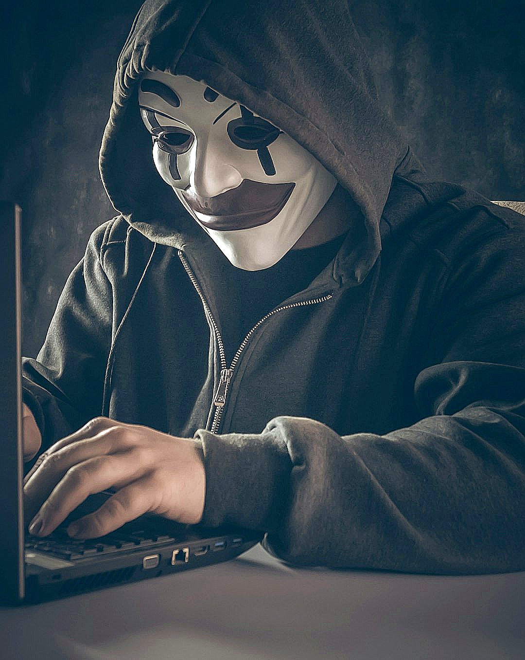 a person wearing a mask using a laptop