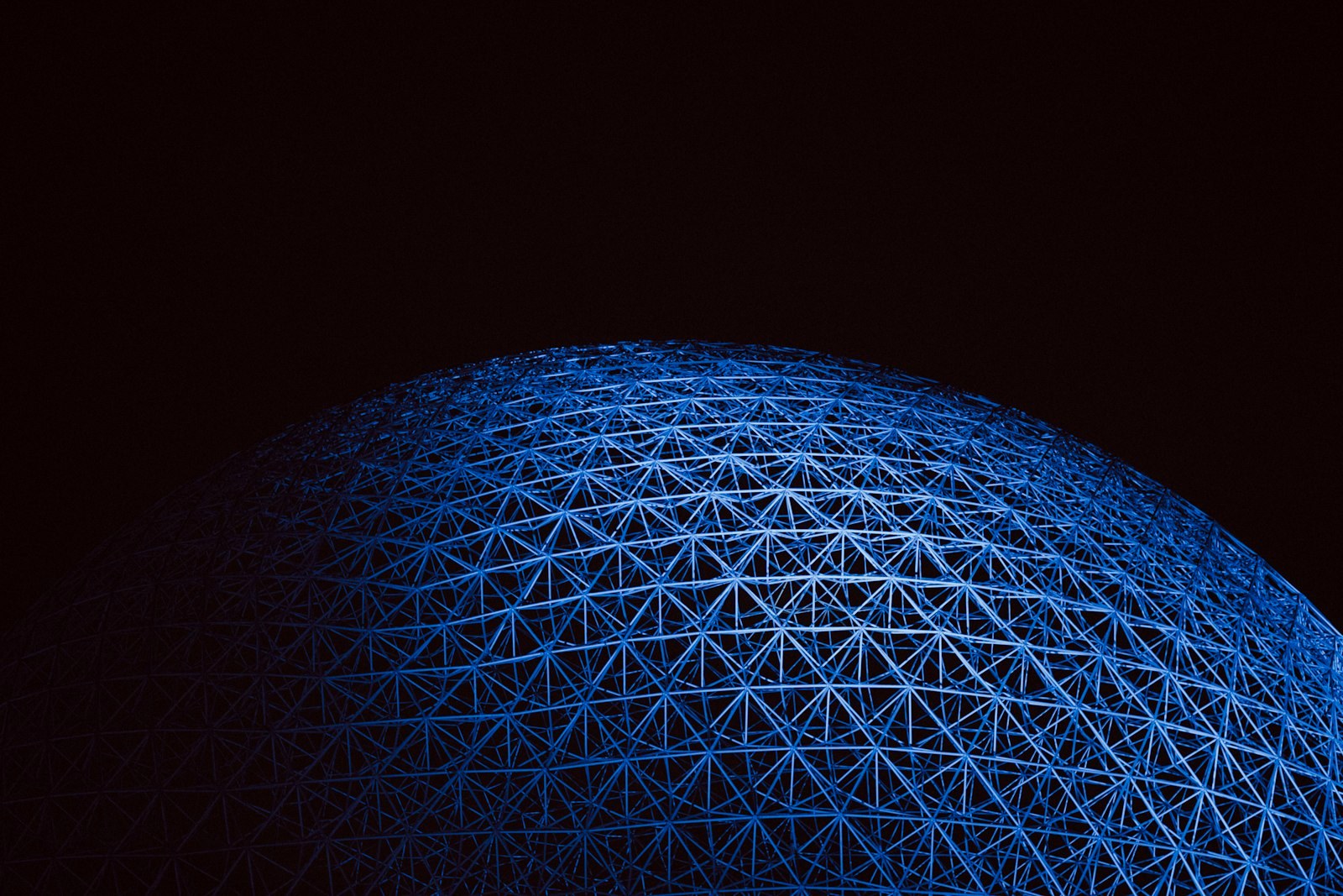 a large blue structure is lit up in the dark