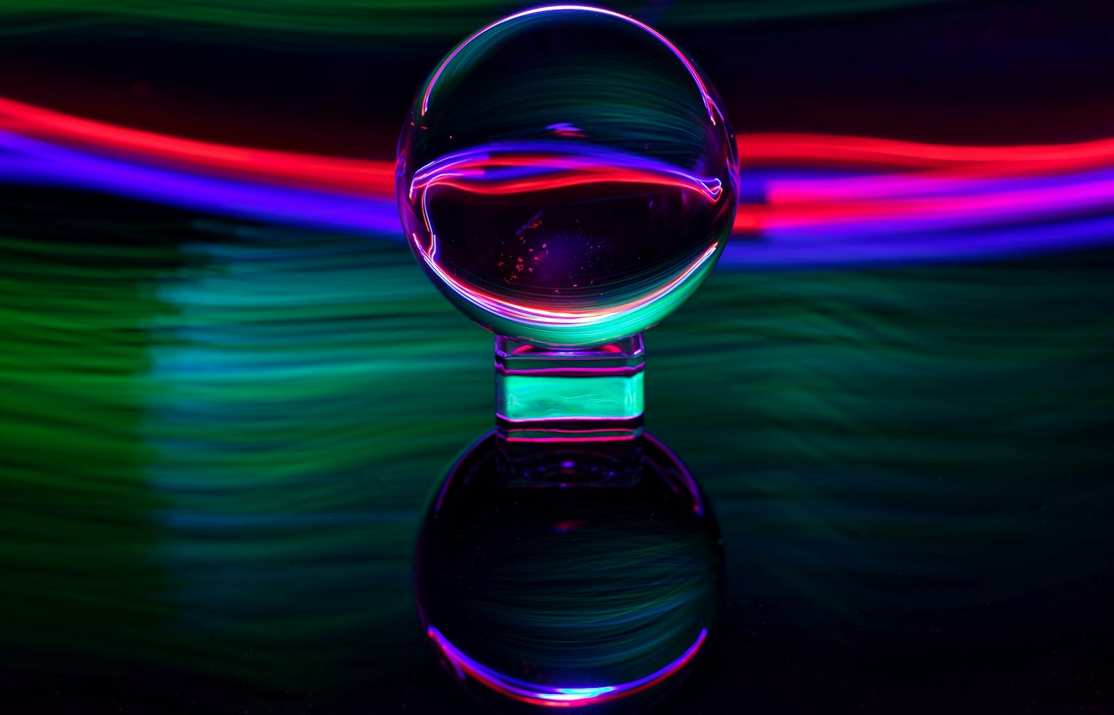 Glass sphere with colorful light trails reflection